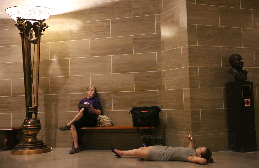 Megan Casady lies on the ground while Sue Gibson sits nearby late into Wednesday night